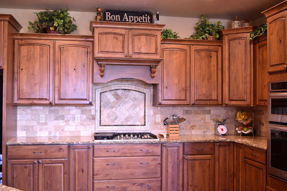 Inredning av ett rustikt stort kök och matrum, med en undermonterad diskho, skåp i mellenmörkt trä, granitbänkskiva, beige stänkskydd, stänkskydd i stenkakel, rostfria vitvaror, mellanmörkt trägolv och en köksö