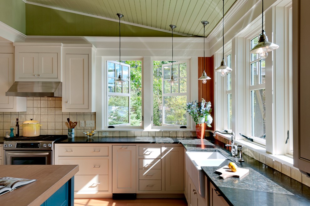 Foto di una cucina stile rurale con elettrodomestici in acciaio inossidabile, lavello stile country, top in granito, ante in stile shaker, ante beige e paraspruzzi beige