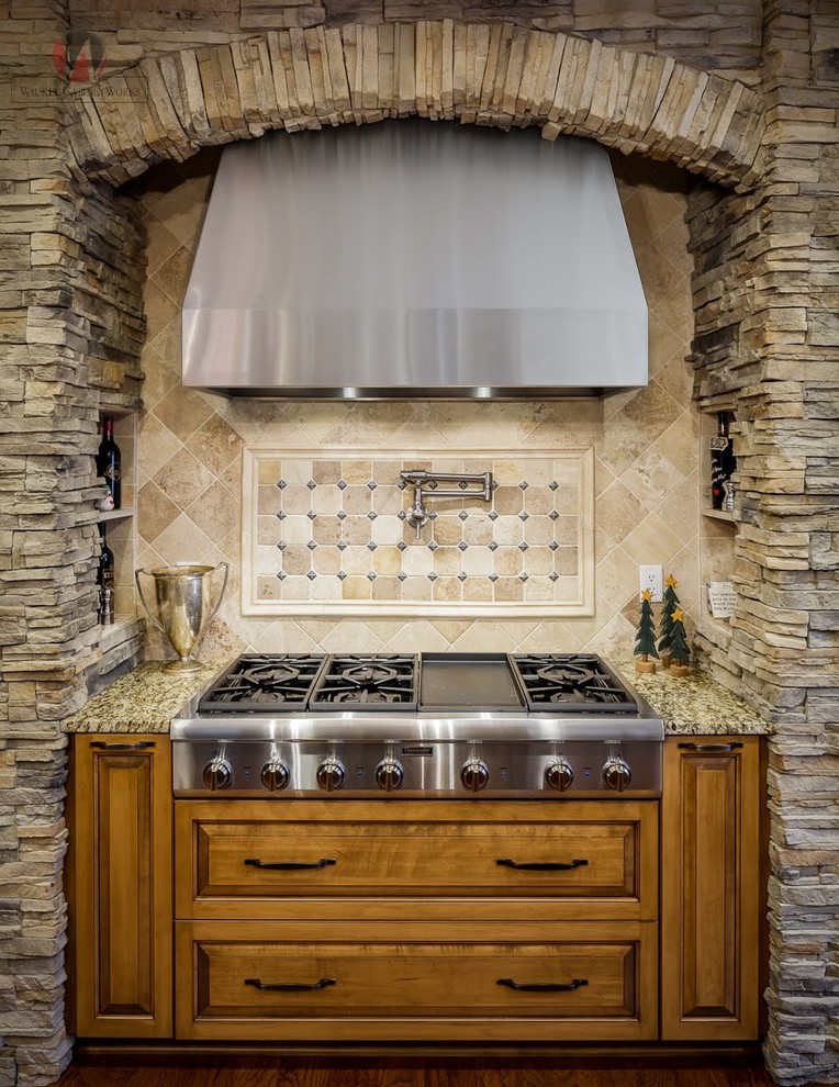 Immagine di una cucina stile rurale con lavello sottopiano, elettrodomestici in acciaio inossidabile e pavimento marrone
