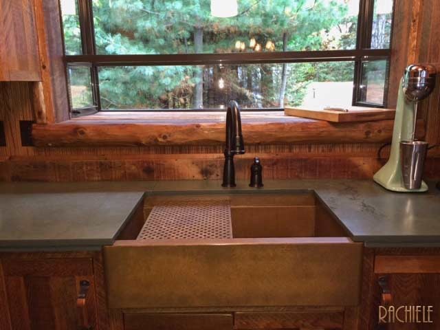 Mid-sized mountain style galley enclosed kitchen photo in Other with a farmhouse sink, shaker cabinets, medium tone wood cabinets, soapstone countertops, brown backsplash, window backsplash and no island