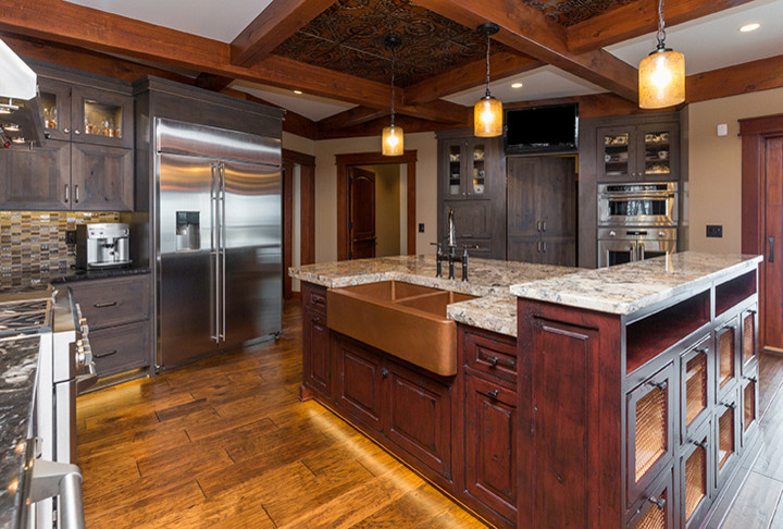 Example of a classic medium tone wood floor kitchen design in Other with red cabinets, stainless steel appliances and two islands