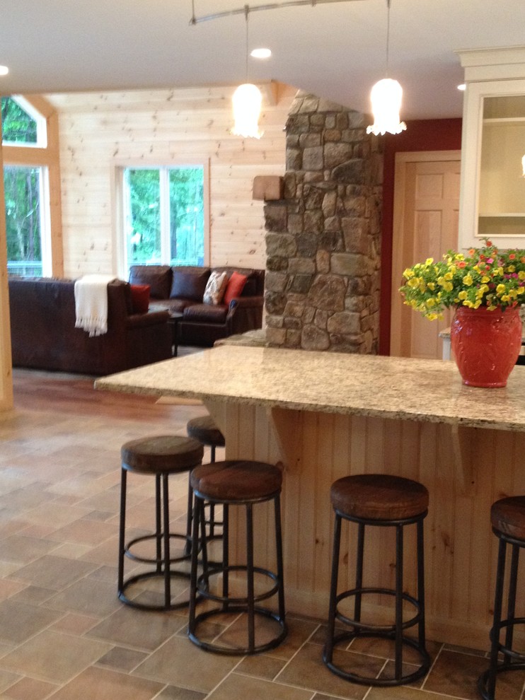 Foto di un cucina con isola centrale stile rurale con ante con bugna sagomata e pavimento in gres porcellanato