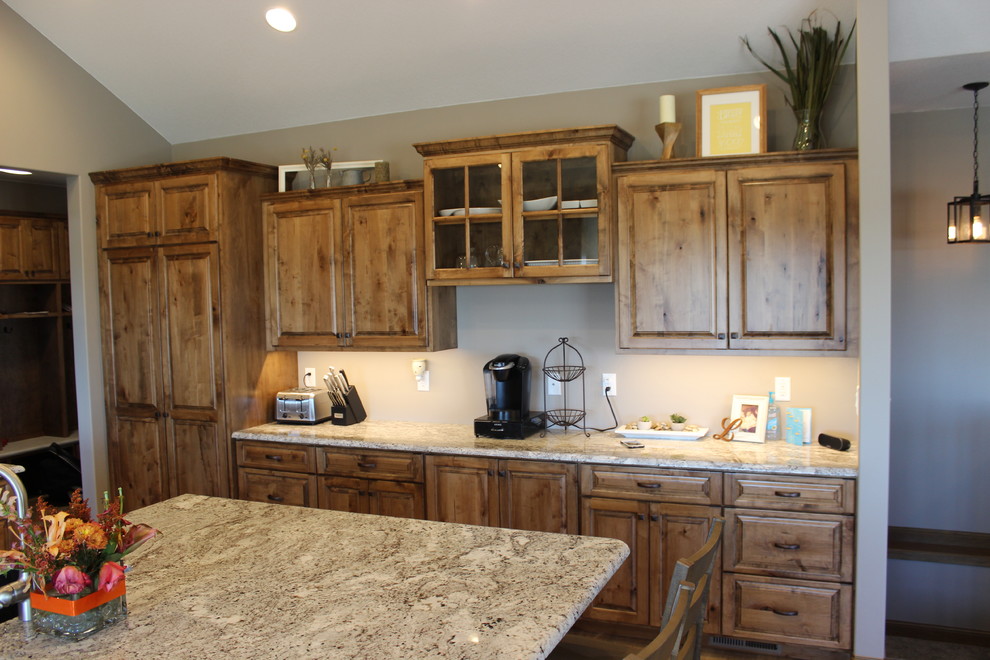 Photo of a large rustic l-shaped open plan kitchen in Other with a submerged sink, raised-panel cabinets, medium wood cabinets, granite worktops, stainless steel appliances, medium hardwood flooring, an island and brown floors.