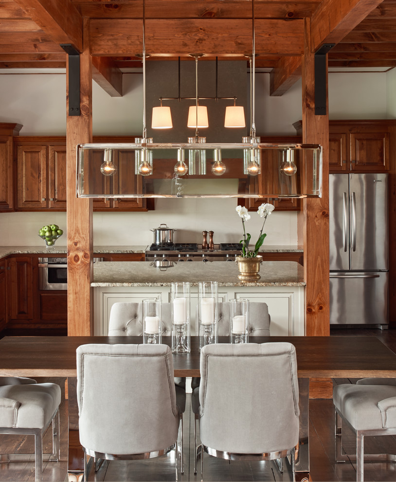 Rustik inredning av ett mellanstort kök, med luckor med upphöjd panel, skåp i mellenmörkt trä, granitbänkskiva, rostfria vitvaror, mellanmörkt trägolv och en köksö