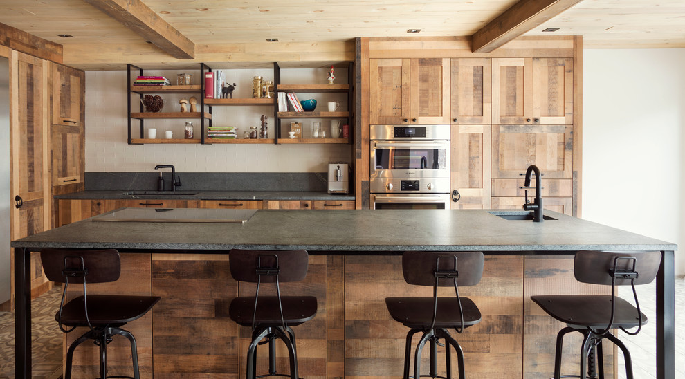 Bild på ett rustikt kök, med en undermonterad diskho, skåp i shakerstil, skåp i mellenmörkt trä, bänkskiva i betong, grått stänkskydd, rostfria vitvaror och en köksö
