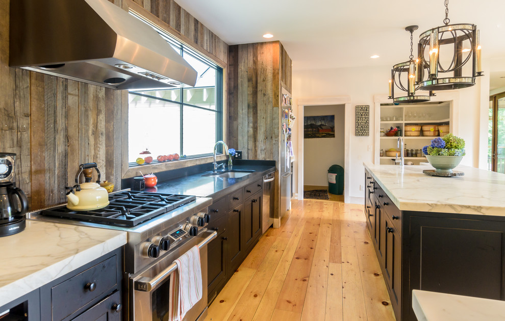 Cottage medium tone wood floor eat-in kitchen photo in Boston with a farmhouse sink, recessed-panel cabinets, dark wood cabinets, marble countertops, stainless steel appliances and an island