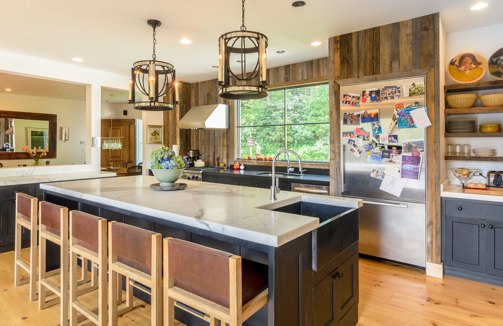 Inspiration for a farmhouse medium tone wood floor eat-in kitchen remodel in Boston with a farmhouse sink, recessed-panel cabinets, dark wood cabinets, marble countertops, stainless steel appliances and an island