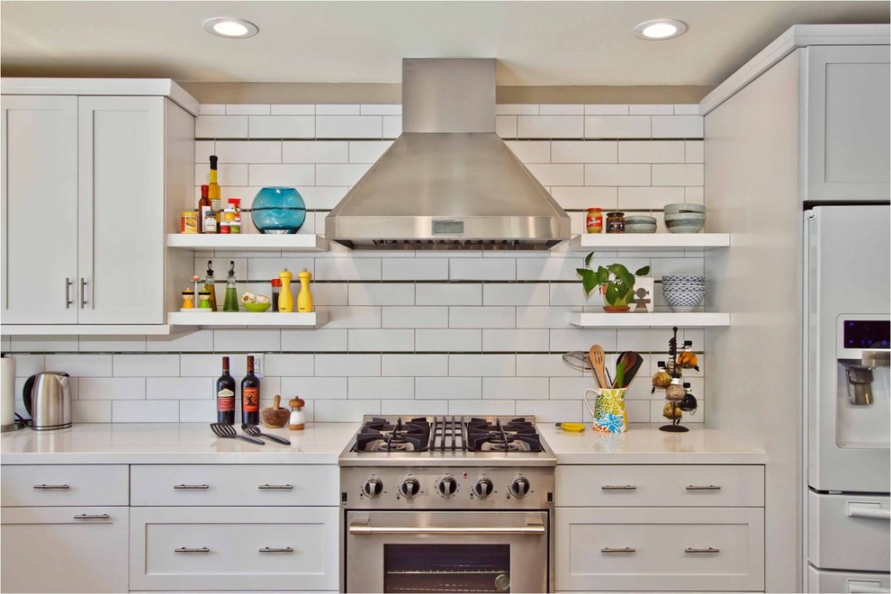 サンディエゴにあるコンテンポラリースタイルのおしゃれなキッチン (サブウェイタイルのキッチンパネル、白いキャビネット、白いキッチンパネル、シルバーの調理設備) の写真