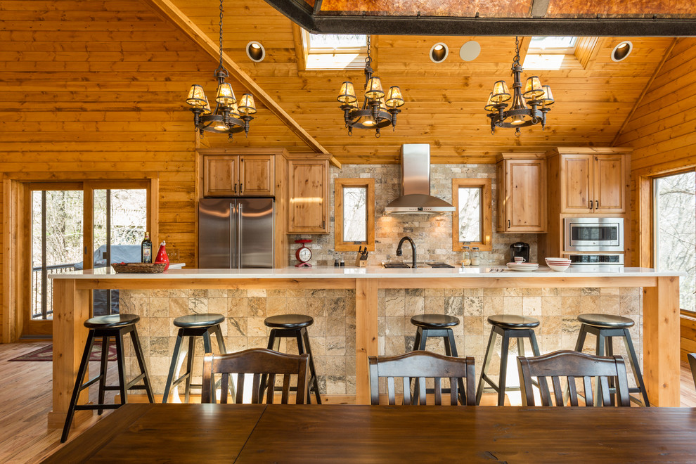Rustik inredning av ett kök, med luckor med upphöjd panel, skåp i mellenmörkt trä och en köksö