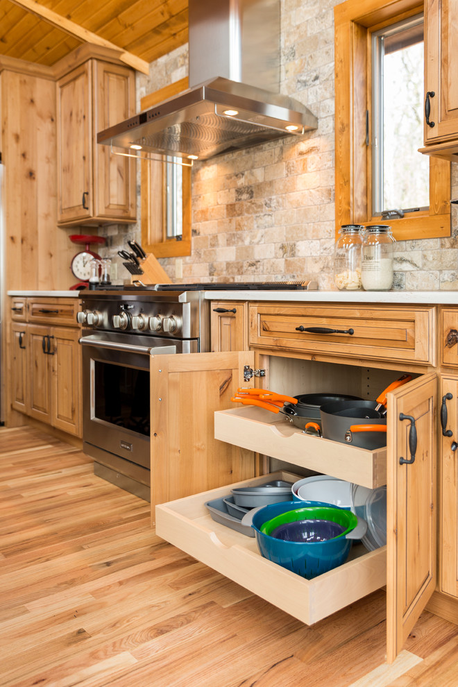 Urige Küche mit profilierten Schrankfronten, hellbraunen Holzschränken und Kücheninsel in Milwaukee