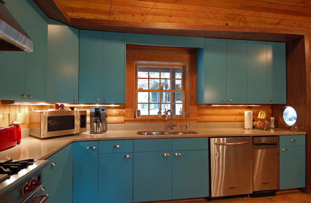 Photo of a medium sized rustic l-shaped kitchen/diner in Charlotte with a submerged sink, flat-panel cabinets, blue cabinets, granite worktops, stainless steel appliances, light hardwood flooring and no island.