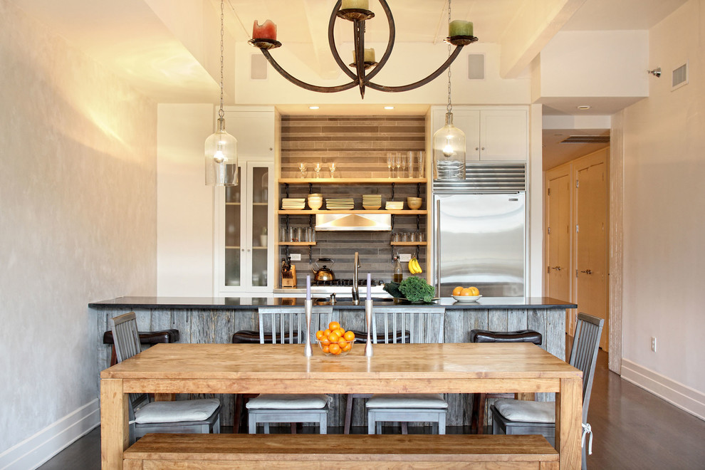 Foto di una cucina minimal di medie dimensioni con lavello sottopiano, ante di vetro, ante bianche, top in granito, paraspruzzi grigio, paraspruzzi con piastrelle in ceramica e elettrodomestici in acciaio inossidabile