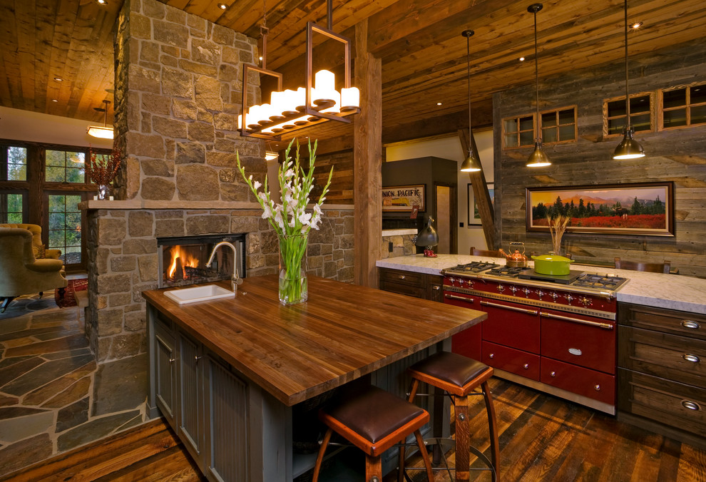 Photo of a medium sized rustic l-shaped open plan kitchen in Other with coloured appliances, an island, a built-in sink, dark wood cabinets, dark hardwood flooring, recessed-panel cabinets, wood worktops and brown floors.