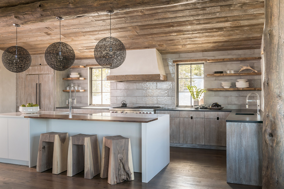 Photo of a rustic l-shaped kitchen in Other with a submerged sink, medium wood cabinets, grey splashback, integrated appliances, medium hardwood flooring, an island, brown floors, grey worktops and flat-panel cabinets.