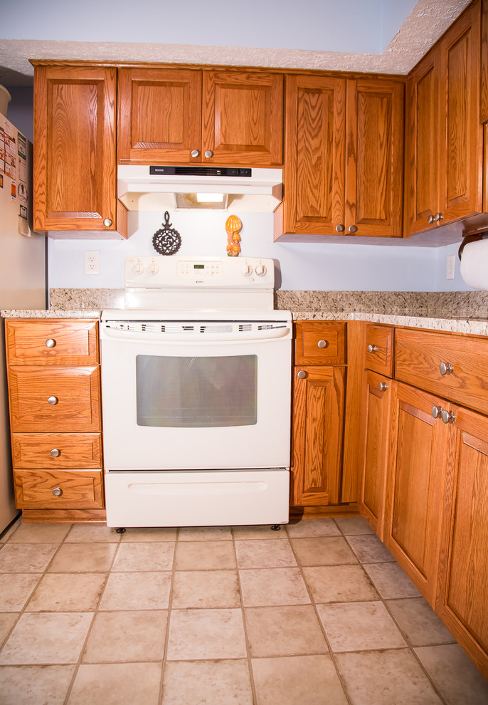 Kleine Rustikale Küche ohne Insel in L-Form mit Doppelwaschbecken, profilierten Schrankfronten, hellbraunen Holzschränken, Küchenrückwand in Blau und weißen Elektrogeräten in Baltimore