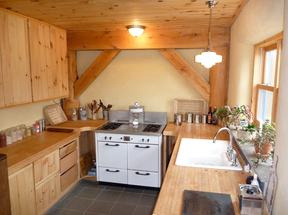 На фото: п-образная кухня в стиле рустика с обеденным столом, светлыми деревянными фасадами, деревянной столешницей и полом из сланца