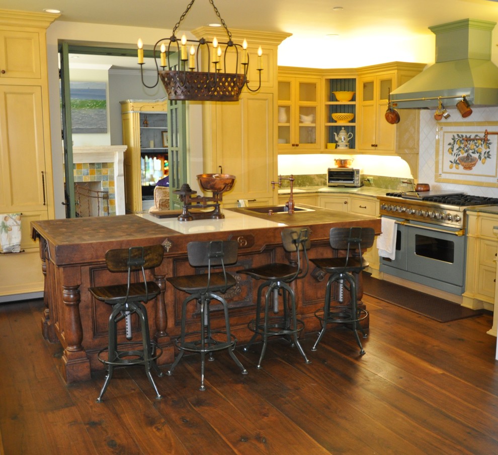 Immagine di una grande cucina classica con lavello da incasso, ante in stile shaker, ante gialle, top in legno, paraspruzzi bianco, elettrodomestici in acciaio inossidabile, parquet scuro e pavimento marrone