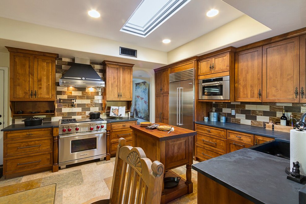 Foto på ett stort amerikanskt kök, med en nedsänkt diskho, släta luckor, skåp i mellenmörkt trä, träbänkskiva, brunt stänkskydd, stänkskydd i stenkakel, rostfria vitvaror, klinkergolv i keramik och en köksö