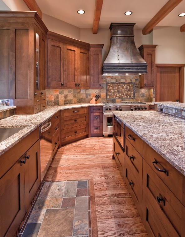 Exemple d'une grande cuisine montagne en L avec un plan de travail en granite, une crédence multicolore, un électroménager en acier inoxydable, un sol en bois brun et îlot.