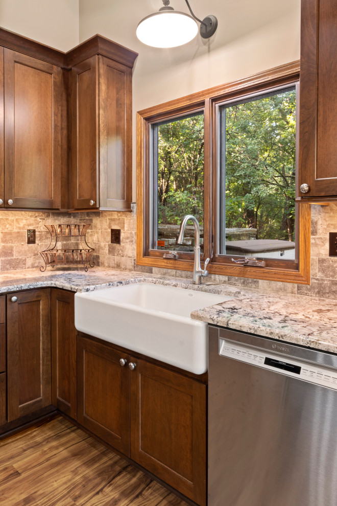 Foto på ett stort rustikt flerfärgad kök, med en rustik diskho, skåp i shakerstil, bruna skåp, granitbänkskiva, flerfärgad stänkskydd, stänkskydd i tunnelbanekakel, rostfria vitvaror, vinylgolv, en köksö och brunt golv