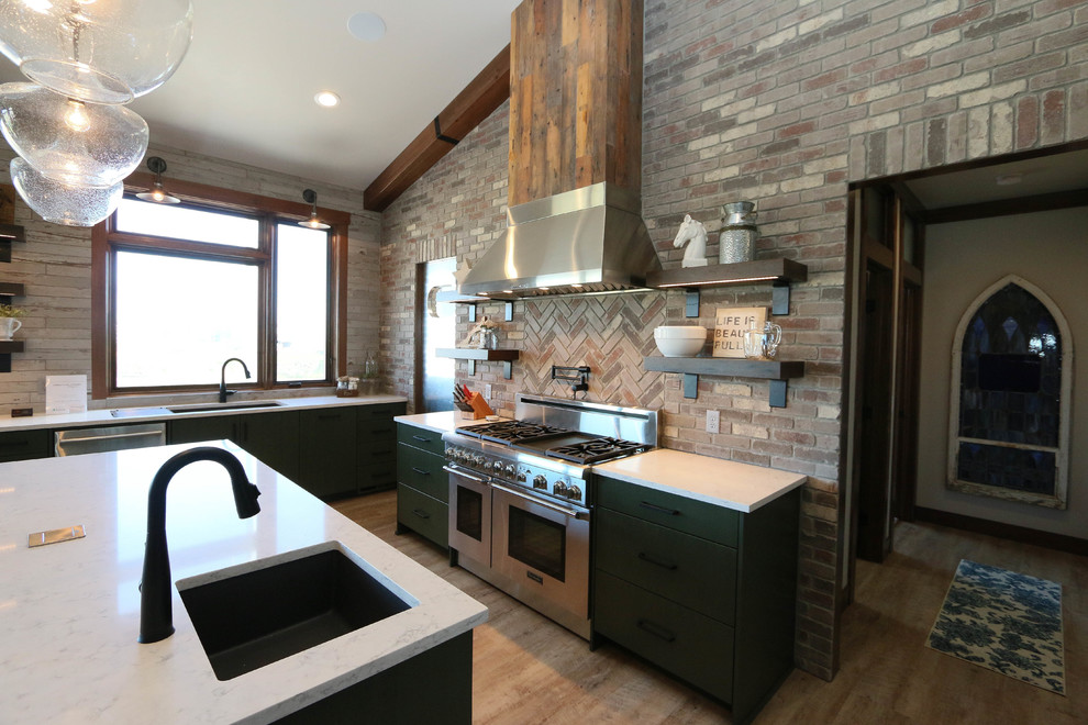 Example of an eclectic vinyl floor eat-in kitchen design in Other with a double-bowl sink, flat-panel cabinets, green cabinets, solid surface countertops, gray backsplash, brick backsplash, stainless steel appliances and an island