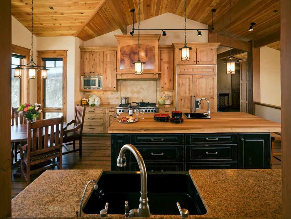 Aménagement d'une cuisine américaine encastrable montagne en bois clair avec un évier 1 bac, un placard à porte shaker, un plan de travail en granite et une crédence beige.