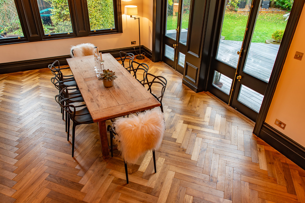 Exemple d'une salle à manger ouverte sur la cuisine montagne avec un sol en bois brun et un sol marron.