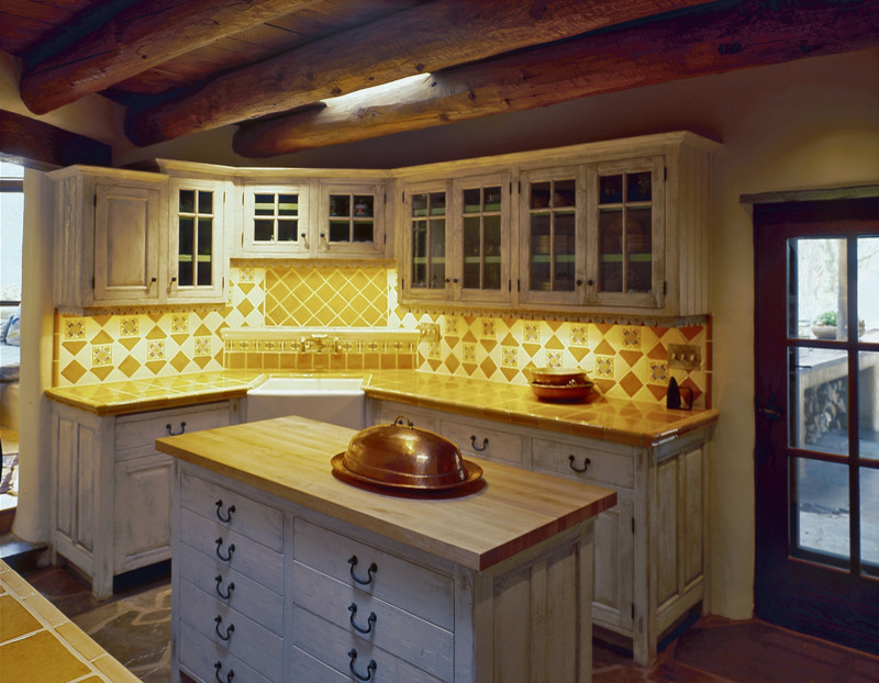 Foto på ett stort lantligt kök, med en rustik diskho, luckor med upphöjd panel, skåp i ljust trä, kaklad bänkskiva, flerfärgad stänkskydd, stänkskydd i keramik, skiffergolv och en köksö
