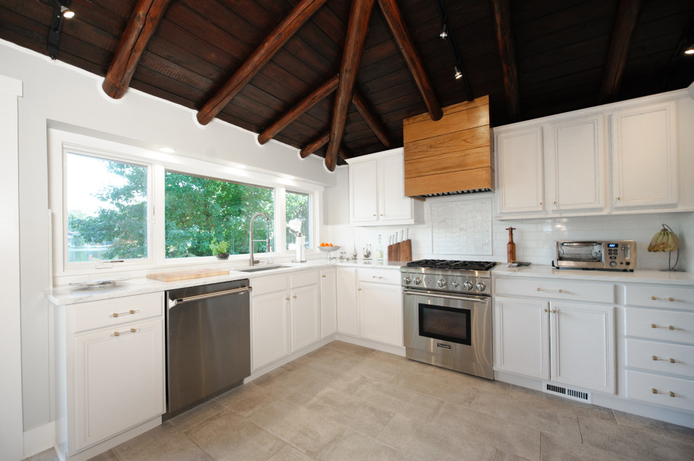 Mid-sized elegant u-shaped porcelain tile and beige floor eat-in kitchen photo in Philadelphia with an undermount sink, recessed-panel cabinets, white cabinets, quartzite countertops, white backsplash, ceramic backsplash, stainless steel appliances, an island and white countertops