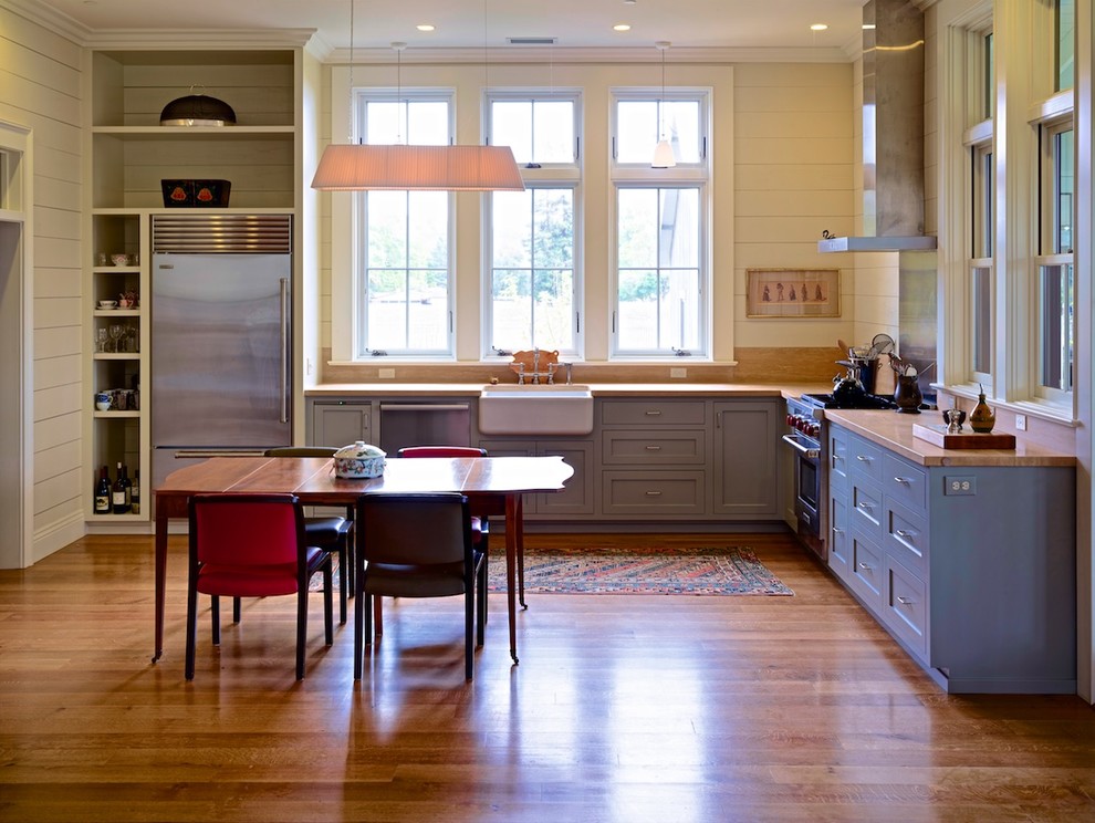 Immagine di una cucina country di medie dimensioni con lavello stile country, ante in stile shaker, ante blu, top in legno, paraspruzzi giallo, paraspruzzi in legno, elettrodomestici in acciaio inossidabile, parquet scuro e nessuna isola