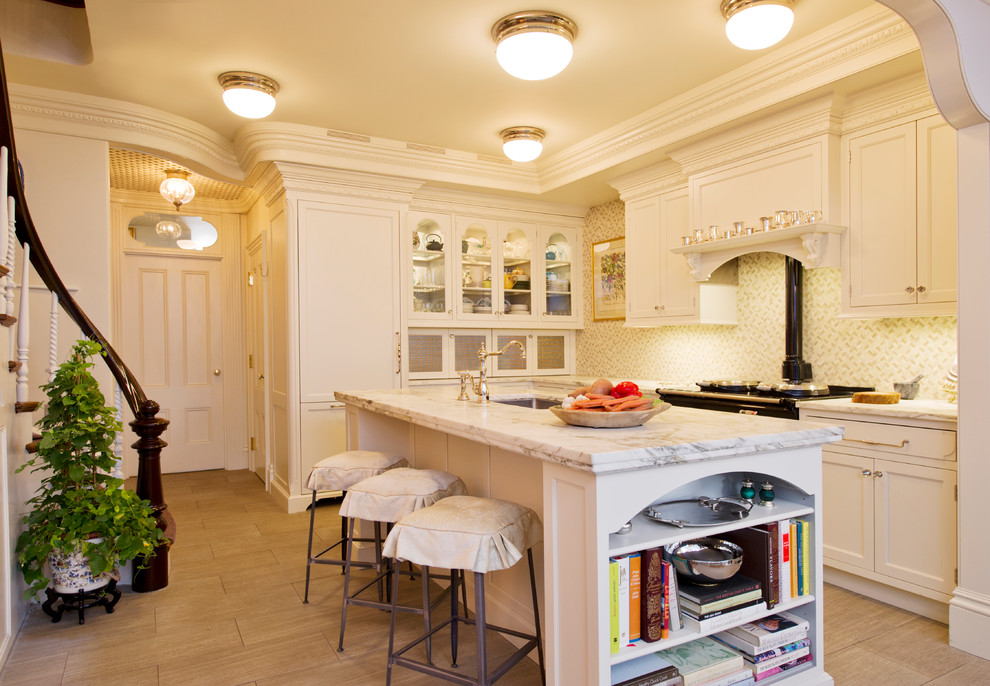 Exempel på ett klassiskt l-kök, med en undermonterad diskho, luckor med infälld panel, vita skåp, beige stänkskydd och integrerade vitvaror