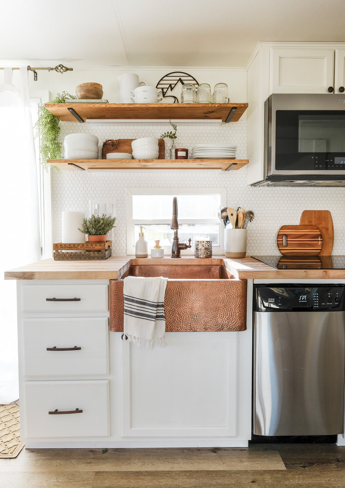 Small cottage galley laminate floor and gray floor kitchen photo in Portland with a farmhouse sink, raised-panel cabinets, white cabinets, wood countertops, white backsplash, porcelain backsplash, stainless steel appliances and no island
