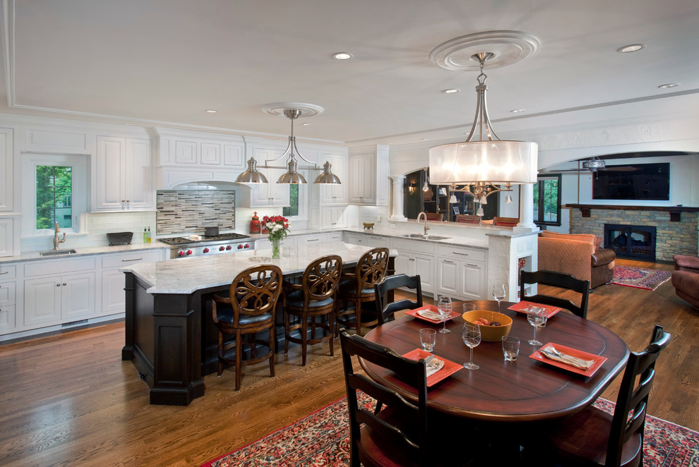 Photo of a large traditional kitchen/diner in Cincinnati with raised-panel cabinets, white cabinets, dark hardwood flooring and stainless steel appliances.