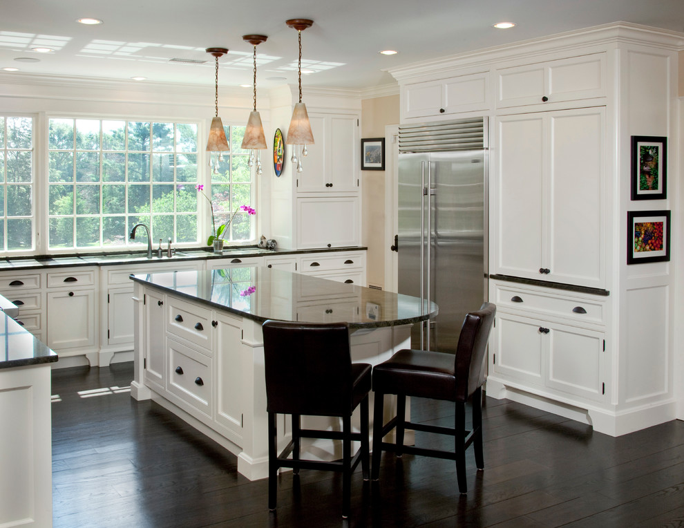 Imagen de cocina tradicional con armarios estilo shaker, puertas de armario blancas, electrodomésticos de acero inoxidable y suelo de madera oscura