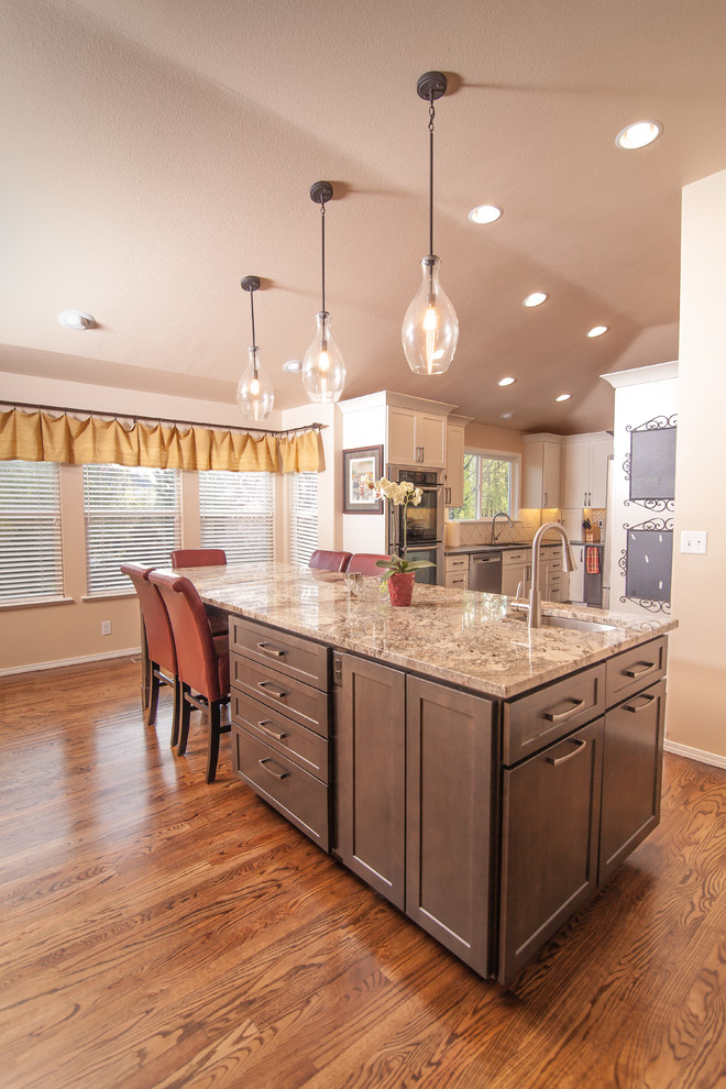 Eat-in kitchen - mid-sized transitional u-shaped light wood floor eat-in kitchen idea in Boise with a double-bowl sink, shaker cabinets, white cabinets, quartz countertops, white backsplash, ceramic backsplash, stainless steel appliances and an island