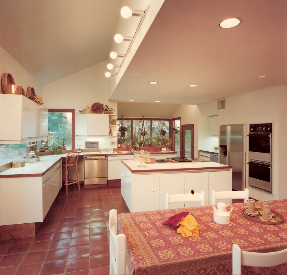 Esempio di una cucina moderna con lavello a tripla vasca, ante lisce, ante gialle, top in marmo e elettrodomestici in acciaio inossidabile