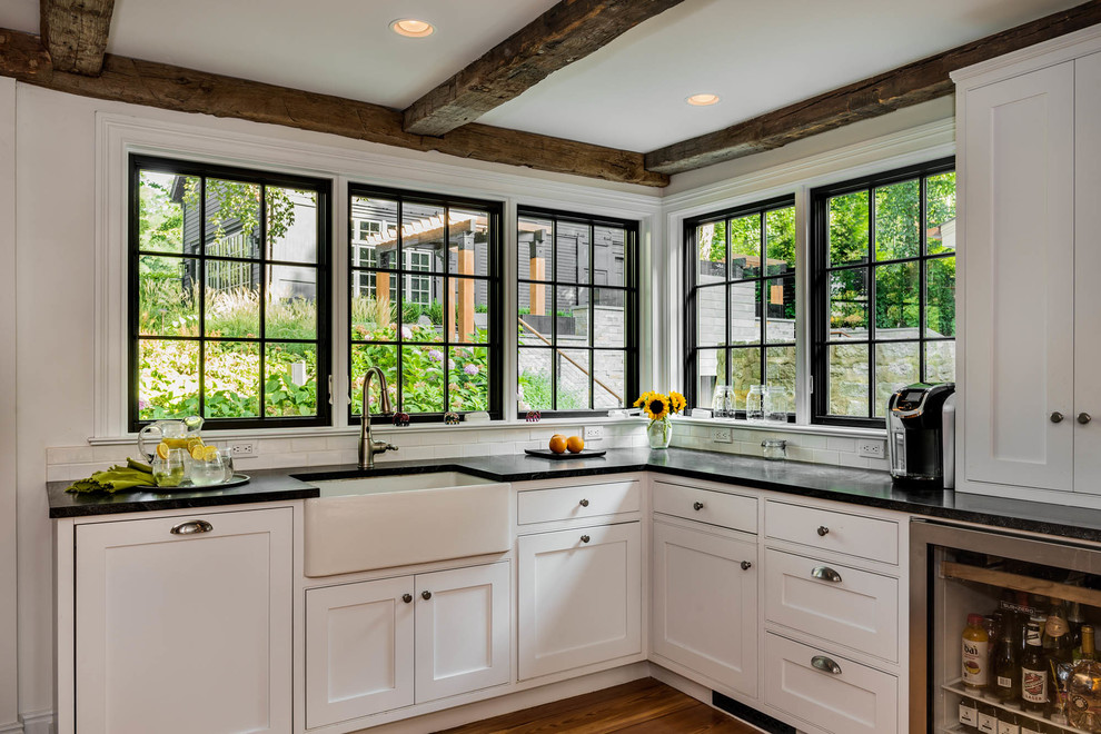 Mittelgroße Klassische Küche mit Landhausspüle, Schrankfronten im Shaker-Stil, weißen Schränken und braunem Holzboden in New York