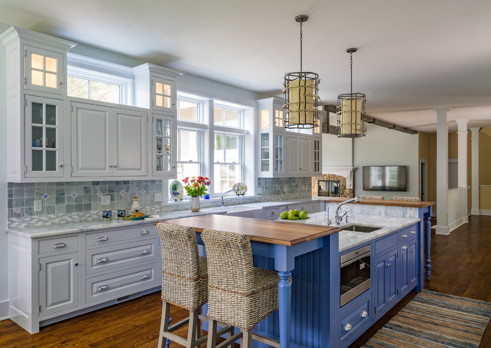 Bild på ett vintage flerfärgad flerfärgat kök med öppen planlösning, med en undermonterad diskho, luckor med upphöjd panel, vita skåp, flerfärgad stänkskydd, rostfria vitvaror, mörkt trägolv och en köksö