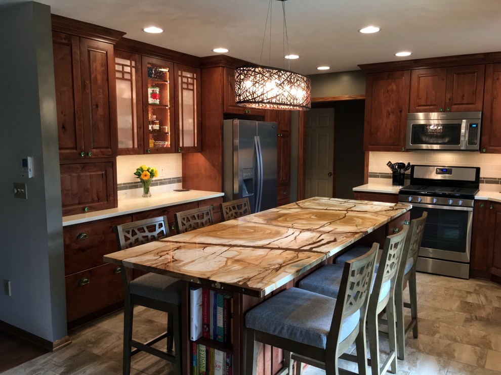 This is an example of a medium sized bohemian kitchen/diner in Other with a submerged sink, raised-panel cabinets, brown cabinets, ceramic splashback, stainless steel appliances, porcelain flooring and an island.