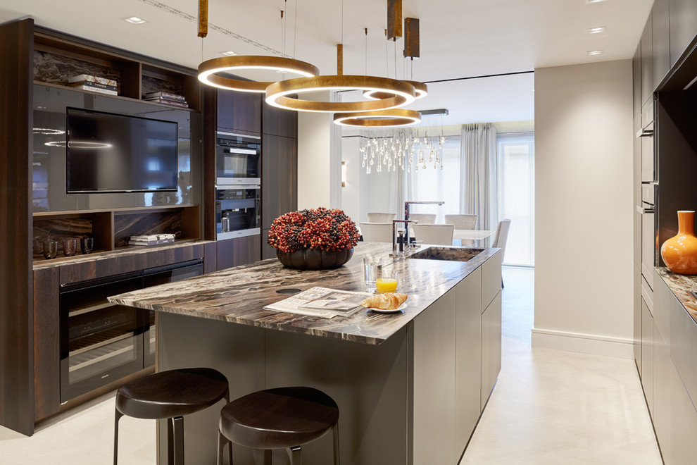 Photo of a contemporary galley enclosed kitchen in London with an integrated sink, flat-panel cabinets, dark wood cabinets, black appliances and an island.