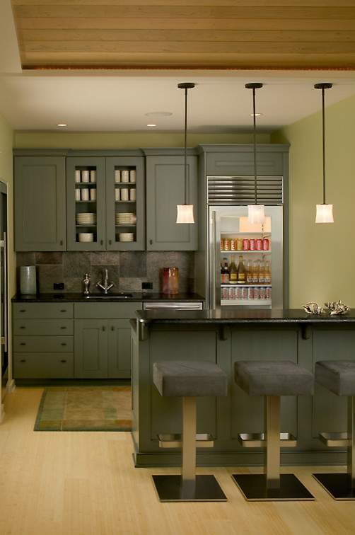 Photo of a large contemporary galley home bar in Grand Rapids with recessed-panel cabinets, grey cabinets, granite worktops, grey splashback, stone tiled splashback and light hardwood flooring.