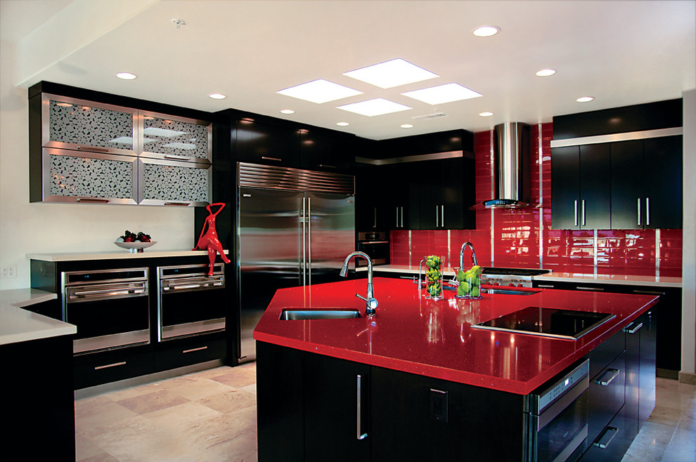 Trendy kitchen photo in Phoenix with stainless steel appliances, an undermount sink, flat-panel cabinets, black cabinets, quartz countertops, red backsplash and red countertops
