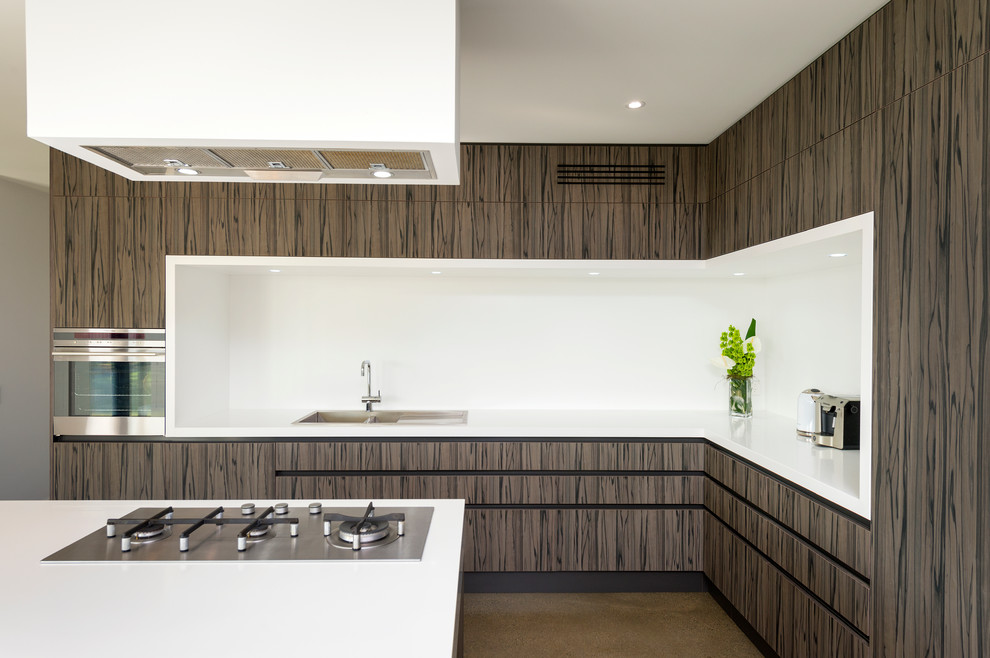 Example of a mid-sized trendy l-shaped travertine floor eat-in kitchen design in Melbourne with an undermount sink, medium tone wood cabinets, quartz countertops, white backsplash, stainless steel appliances and an island