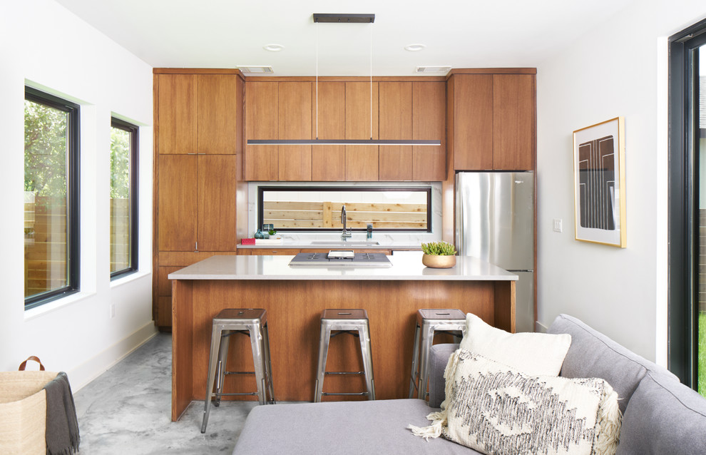 Esempio di una cucina contemporanea con ante lisce, ante in legno scuro, paraspruzzi a finestra, elettrodomestici in acciaio inossidabile, pavimento grigio e top grigio