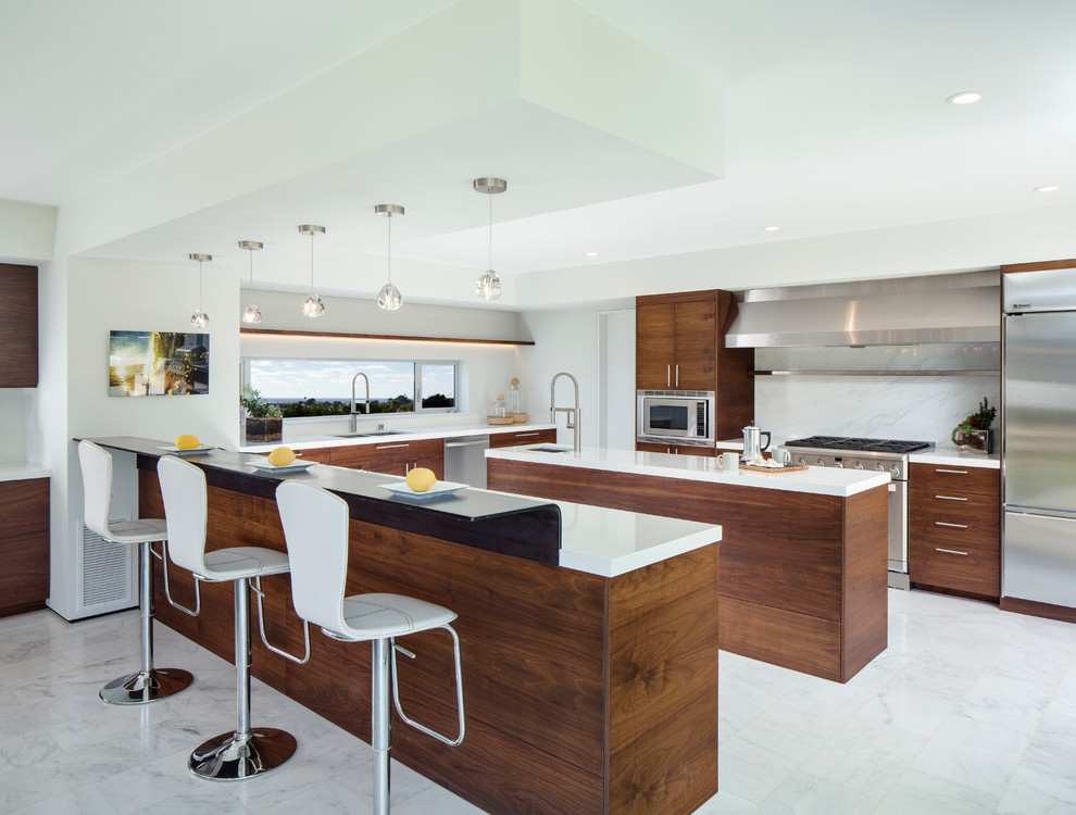 Contemporary u-shaped kitchen in San Diego with a double-bowl sink, flat-panel cabinets, dark wood cabinets, white splashback, stainless steel appliances and multiple islands.