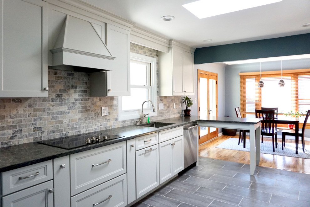 Example of a mid-sized transitional galley eat-in kitchen design in Denver with an undermount sink, shaker cabinets, white cabinets, quartz countertops, beige backsplash, stainless steel appliances, a peninsula and gray countertops