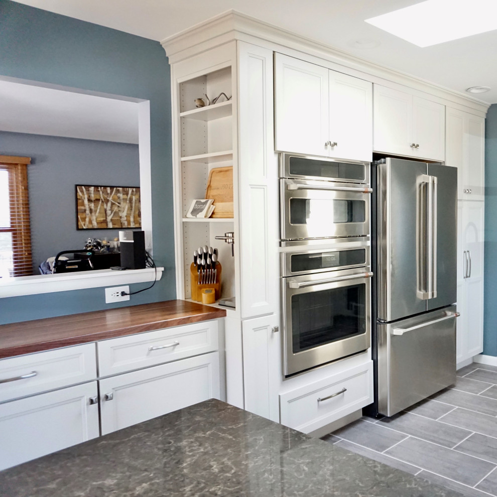 Medium sized traditional galley kitchen/diner in Denver with a submerged sink, shaker cabinets, white cabinets, engineered stone countertops, beige splashback, stainless steel appliances, a breakfast bar and grey worktops.
