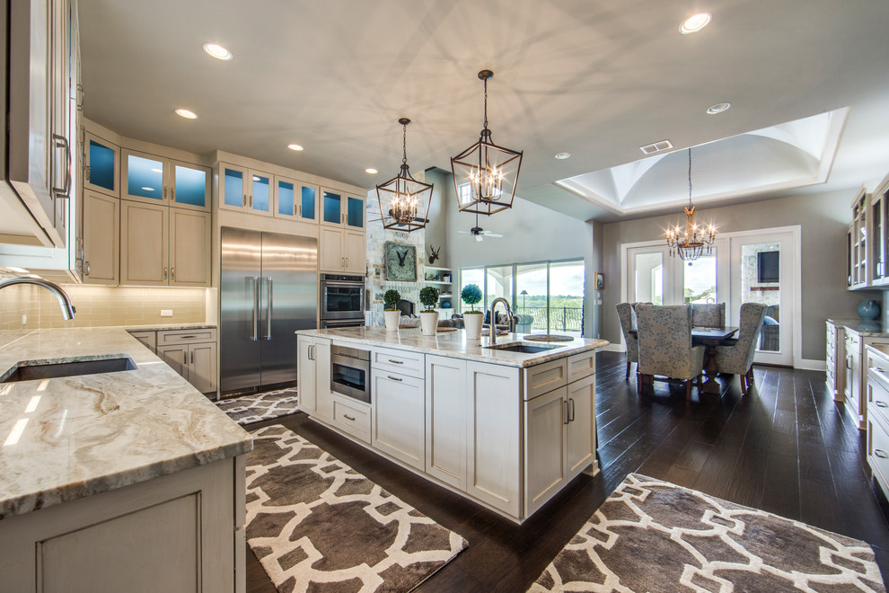 Inspiration for a transitional dark wood floor kitchen remodel in Dallas with a single-bowl sink, shaker cabinets, white cabinets, marble countertops, beige backsplash, glass tile backsplash, stainless steel appliances and an island