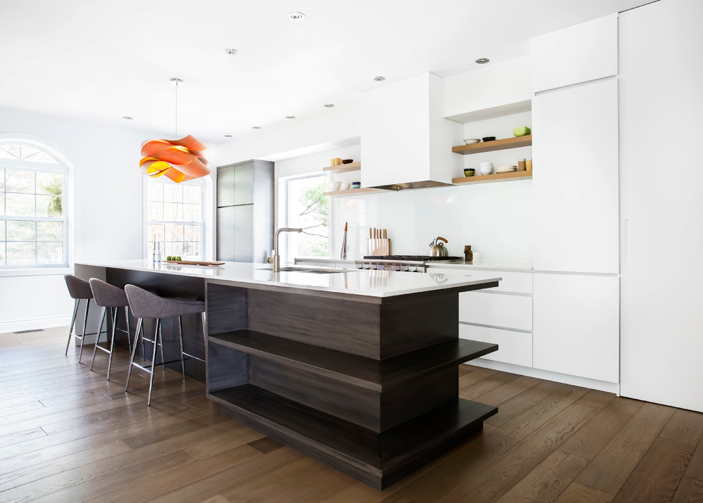 Photo of a contemporary galley kitchen in Montreal with flat-panel cabinets and white cabinets.