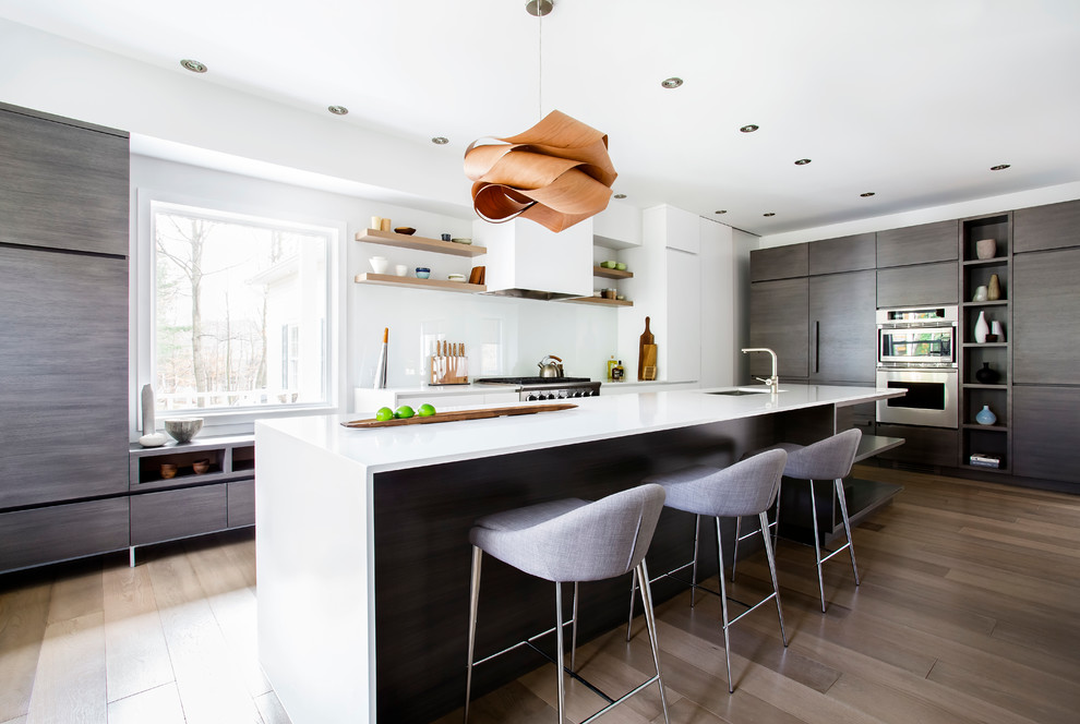 Geschlossene, Zweizeilige Moderne Küche mit flächenbündigen Schrankfronten, hellbraunen Holzschränken, Küchenrückwand in Weiß und Glasrückwand in Montreal